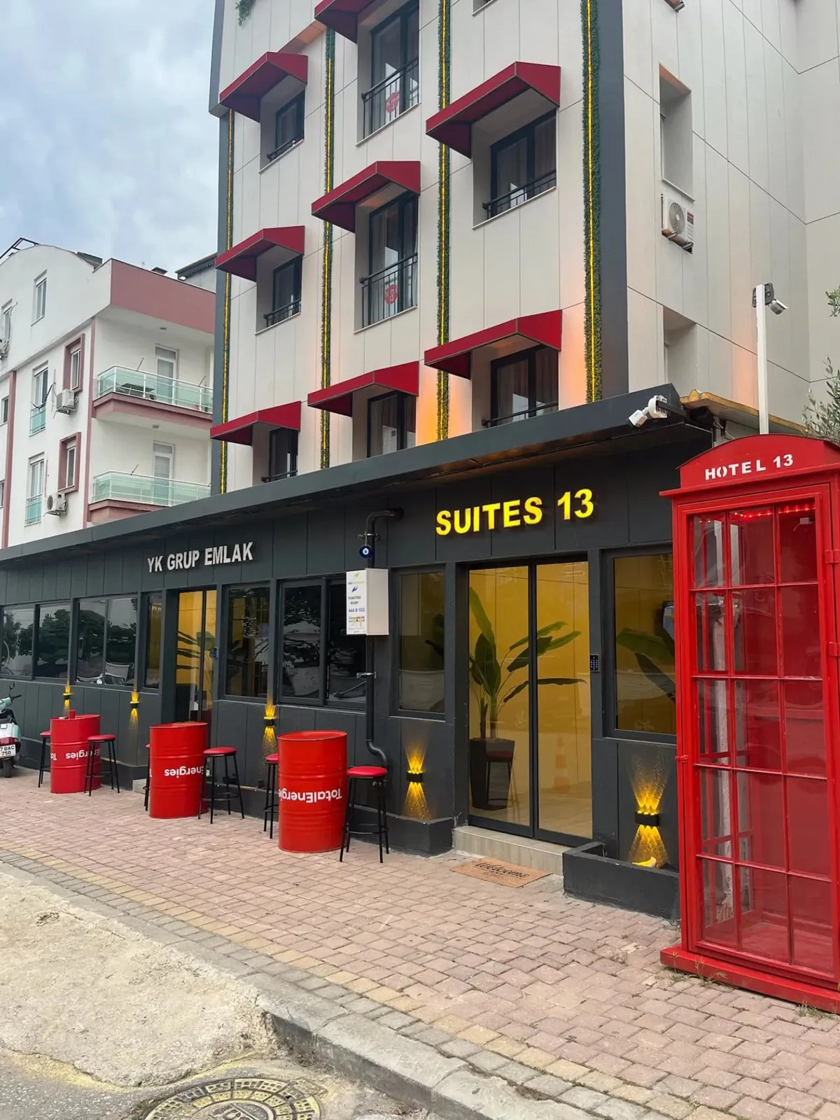 Hotel 13 girişi ve kırmızı telefon kulübesi, gündüz
